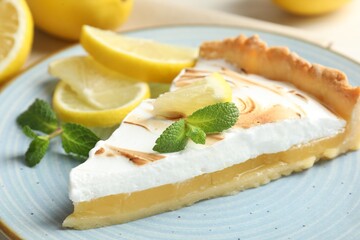 Slice of tasty lemon meringue tart served on table, closeup