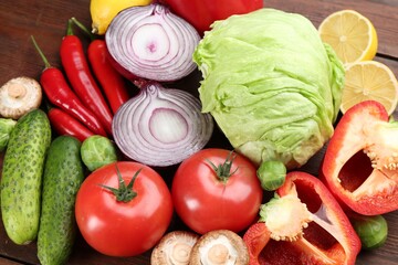 Different fresh raw vegetables and lemons on wooden table, flat lay