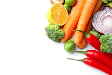 Different fresh raw vegetables and lemon on white wooden table, flat lay. Space for text