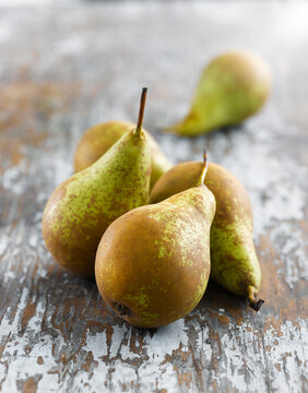 Organic Conference pears in rustic still life on wooden table