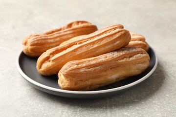 Delicious eclairs on light grey table, closeup