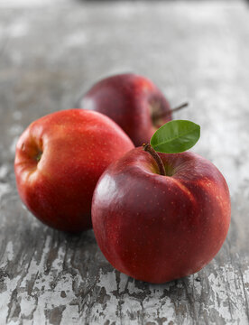 Three fresh red apples including Jonagold and Red Delicious varieties