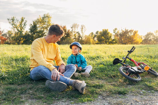 Father and son bonding outdoors with bicycle learning and support