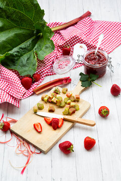 Strawberry and rhubarb jam with fresh ingredients on wood