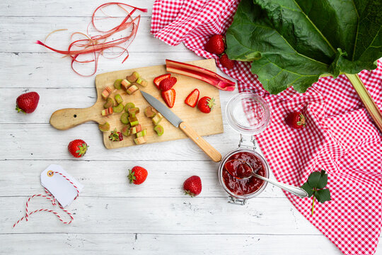 Strawberry rhubarb jam with strawberries and rhubarb on wooden table