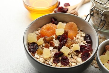 Making granola. Oat flakes, dried fruits and other ingredients on white table, closeup