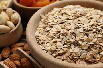 Making granola. Oat flakes, dried fruits and other ingredients on table, closeup