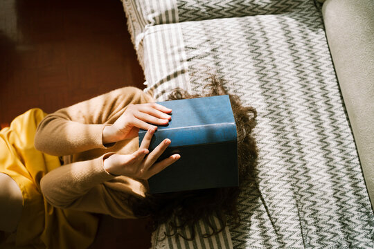 Woman relaxing at home with book on face enjoying leisure time