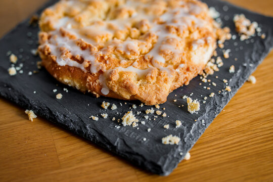 Streuselschnecke pastry with icing on graphite plate