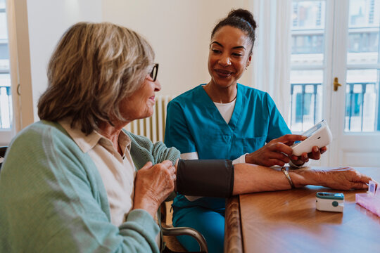 Nurse measuring blood pressure of elderly woman during in-home care