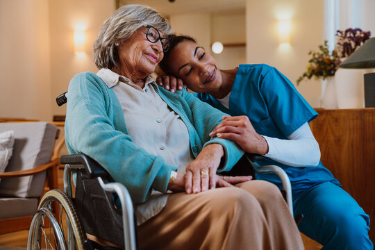 Caregiver providing compassionate assistance to elderly woman in wheelchair