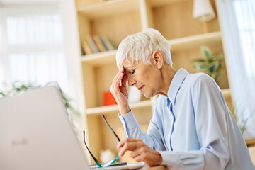 Portrait of a mature senior woman a businesswoman working on laptop  from home having a meeting online having a headache or being stressed, home office, or a student learning, or mature woman surfing 