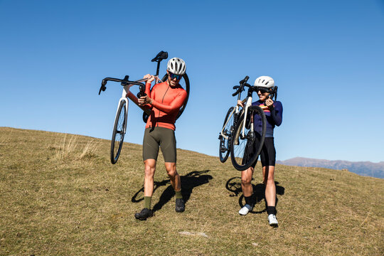 Couple carrying road bikes outdoors in the Pyrenees mountains