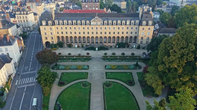 Drone advancing over Jardin and Palais Saint-Georges in Rennes, France during sunrise.