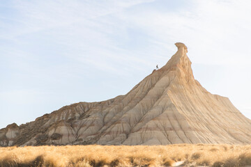 Man trekking with backpack at sunrise in Bardenas Reales desert Spain