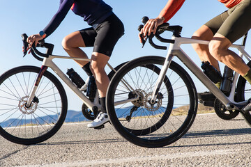 Couple cycling on road bikes in the Pyrenees mountains outdoors
