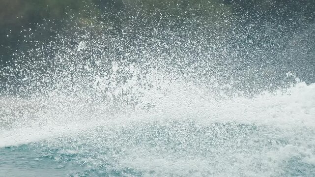 Pro surfer rides the wave and does radical turn with a lot of spray