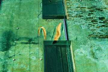Façade de maison abandonnée derrière une bâche transparente.