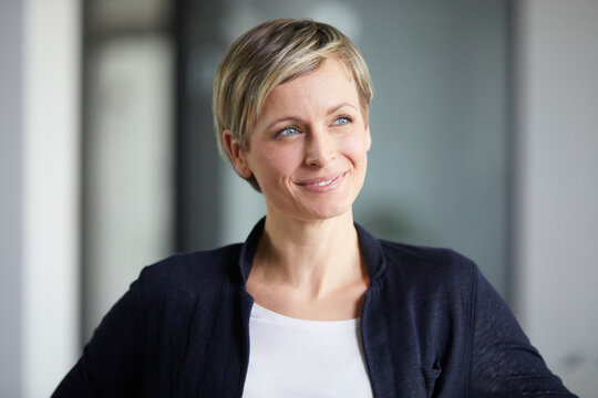 Businesswoman in office smiling and looking away