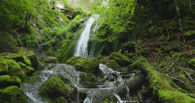 Beautiful waterfall cascades through lush greenery in the heart of France's natural landscape