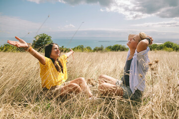 Women relaxing in tall grass enjoying nature and expressing gratitude