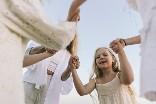 Family holding hands in circle outdoors demonstrating bonding and joy