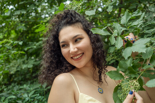 Confident woman smiling in summer greenery outdoors portrait