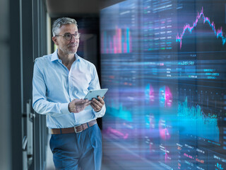 Engineer analyzing financial data on tablet in server room