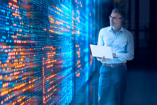 Engineer analyzing data on tablet in modern server room