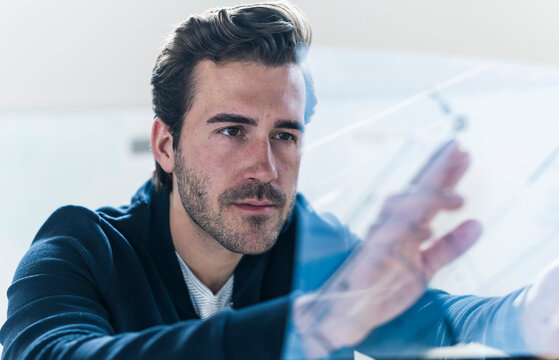 Businessman working with transparent screen in modern office