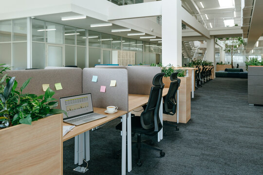 Modern coworking office interior with desks and laptops