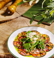 Beautifully arranged vegetable carpaccio with fresh herbs and olive oil