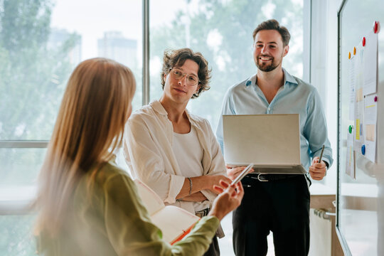 Colleagues discussing strategy at office board during meeting