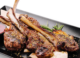 Delicious grilled lamb chops served with herbs and sauce