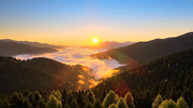 Sunrise over mountain range with low-lying clouds, trees in foreground, bright sun and orange sky