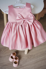 Little girl’s pink dress with bow on hanger