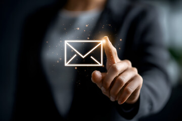 Close up of female hand tapping a glowing email symbol icon,  strategies and digital business communication emphasizing newsletter distribution 