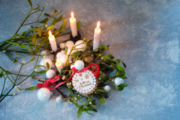 festive composition with burning candles, mistletoe branches, christmas white glass balls, greeting...