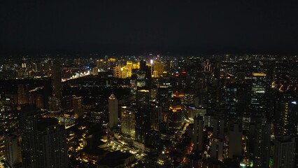 Naklejka premium Manila with night skyline highlights its bustling streets, illuminated buildings, and dynamic urban lifestyle. Metro Manila, Philippines.