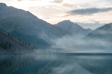 fog at sunset over Shavlinsky Lake, a turquoise mountain lake in Altai