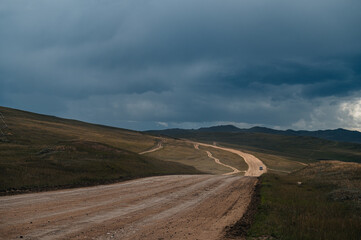an empty country road on Olkhon Island with dramatic clouds in the sky