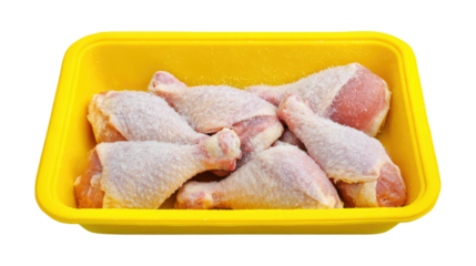 Frozen chicken legs in a yellow tray isolated on a white background
