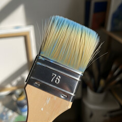 Close up of an isolated artist's paintbrush with wood handle and bristles for color painting