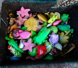 Used plastic fish and sea animal figures found in the trash. Unused colored plastic toys.