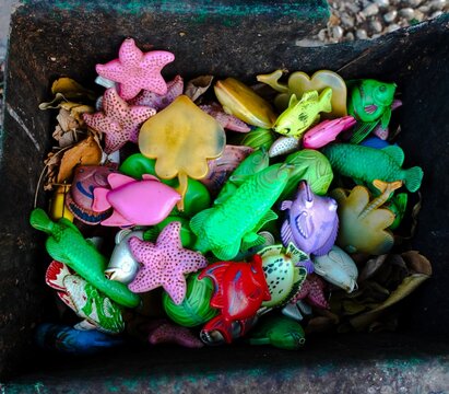 Used plastic fish and sea animal figures found in the trash. Unused colored plastic toys.