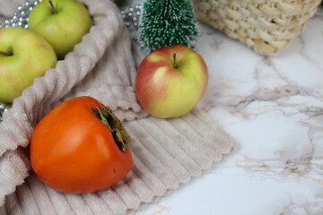 Winter apples and persimmons stand on the table on winter days