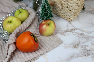 Winter apples and persimmons stand on the table on winter days