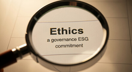 Focused analysis of business ethics and corporate governance. An esg commitment with magnifying glass over financial document for an audit of company compliance and integrity