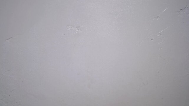 Cleaning textured wall with wet orange microfiber cloth producing rich wiping sound, highlighting hygiene routine, dust removal efficiency, detailed close-up household cleanliness concept