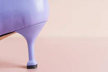 One elegant lavender color kitten heel of purple leather craft female shoe on soft pink or pastel beige background with copy space representing quality of leatherwork craftsmanship of modern footwear